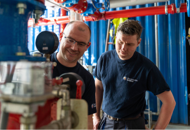 Zwei Service-Mitarbeiter sichern mit der Wartung einer Sprinkleranlage deren Betriebsbereitschaft
