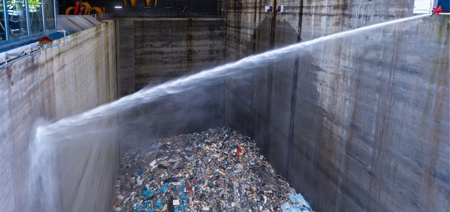 Löschvorgang im Müllbunker des Heizkraftwerks Stapelfeld – Wasserstrahl trifft auf brennbaren Abfall
