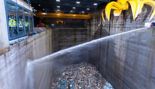 Löschvorgang im Müllbunker des Heizkraftwerks Stapelfeld – Wasserstrahl trifft auf brennbaren Abfall