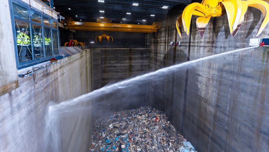 Löschvorgang im Müllbunker des Heizkraftwerks Stapelfeld – Wasserstrahl trifft auf brennbaren Abfall