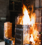 Kontrollierter Brand von Paletten und Kisten im Brandhaus zur Analyse der Löschwirkung im Brandschutzversuch