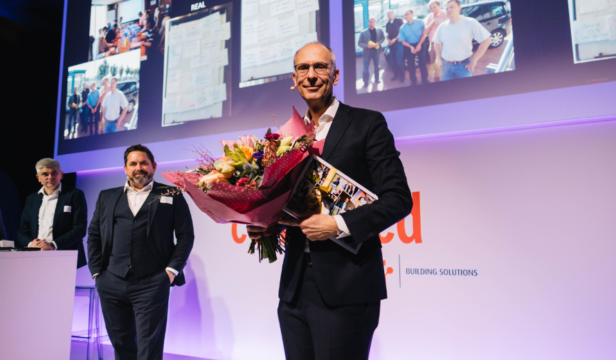 Ehrung von Stefan Falk für 25 Jahre Firmenzugehörigkeit bei der Fire Protection Solutions, mit Blumenstrauß und Geschenk auf der Bühne