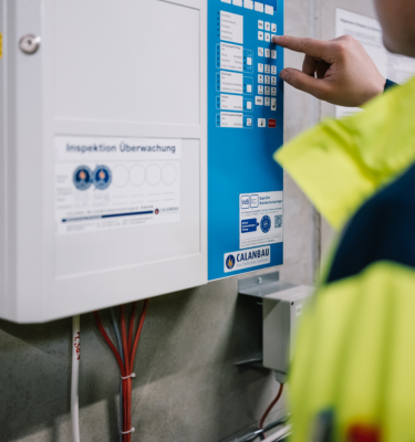 Person bedient das Bedienfeld einer Brandmeldezentrale