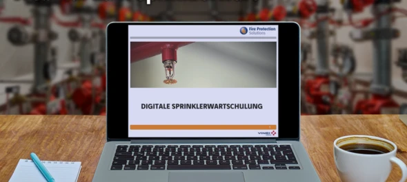 Laptop mit digitaler Sprinklerwartschulung vor Sprinkleranlage